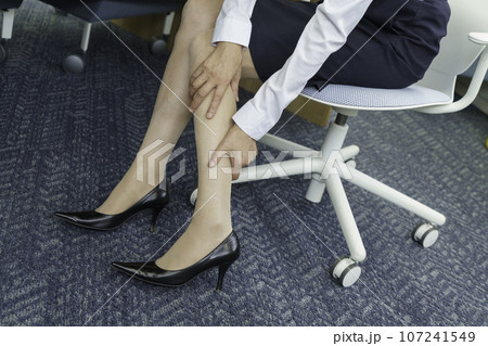 オフィスで足のむくみを気にする女性の足元 107241549