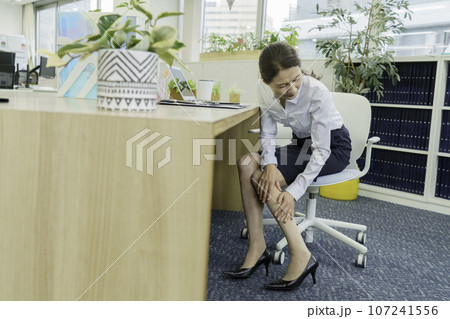 オフィスで足のむくみを気にする女性 107241556