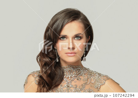 Pretty fashion model woman in diamond jewelry and silver evening gown portrait Pretty fashion model woman in diamond jewelry and silver evening gown portrait 107242294