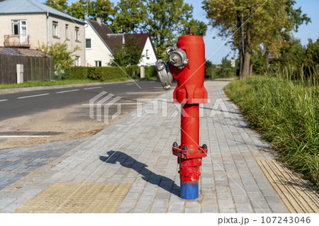 Single red fire hydrant standing on city street Single red fire hydrant standing on city street 107243046