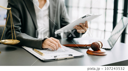 justice and law concept. Male judge in a courtroom the gavel, working with smart phone and laptop and digital tablet computer on table . 107243532