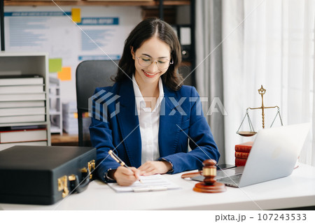 Beautiful woman lawyer working and gavel, tablet, laptop in front, Advice justice and law concept.. 107243533