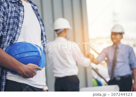 Contractor construction engineer meeting talking together on architect table at construction office site. Businessman engineer manager discuss with foreman team builder look at plan blueprint laptop Contractor construction engineer meeting talking together on architect table at construction office site. Businessman engineer manager discuss with foreman team builder look at plan blueprint laptop 107244523
