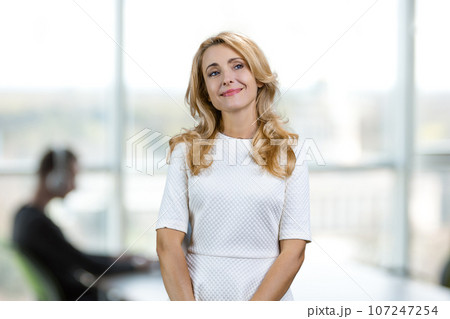 Pensive dreamful beautiful middle aged woman in office. Blurred indoor background. Pensive dreamful beautiful middle aged woman in office. Blurred indoor background. 107247254
