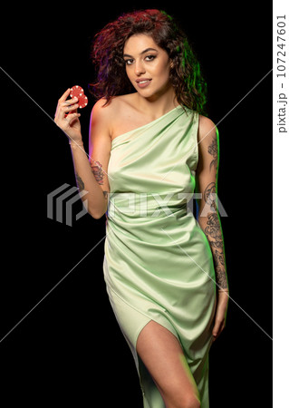 Successful young female poker player holding two betting chips 107247601