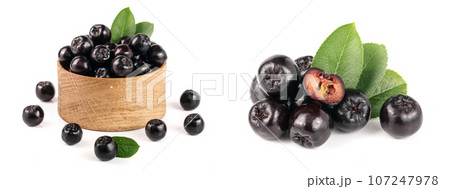 Chokeberry with leaf in wooden bowl isolated on white background. Black aronia berries Chokeberry with leaf in wooden bowl isolated on white background. Black aronia berries 107247978
