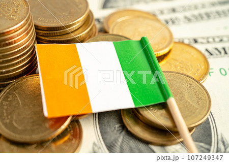 Stack of coins with Ireland flag and US dollar banknotes. 107249347