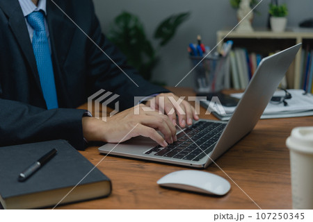 man sitting at a desk, typing on a laptop keyboard computer. of online connectivity and job search in our personal. as technology, social media, online marketing, and education. 107250345