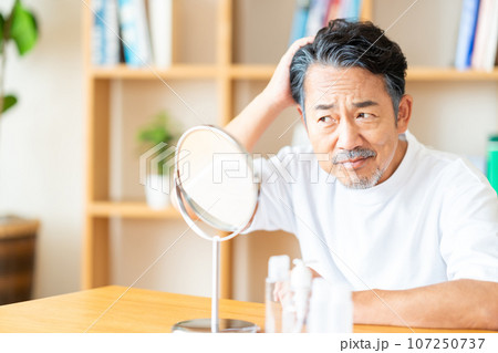 頭髪が気になる中年の男性。 頭髪が気になる中年の男性。 107250737