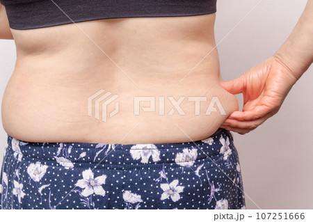 【わき腹の肉を摘む主婦の後ろ姿】 107251666