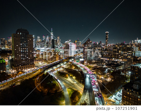 Evening in modern urban borough in metropolis. glowing high rise buildings and heavy traffic on multilane roads. Colourful city lights. New York City, USA 107251901