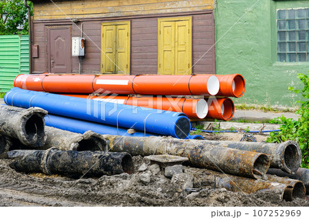 Replacement of water supply and sewer pipes, dirty old pipes next to new modern plastic pipes 107252969