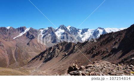 Rocky pass with a view of the snowy mountains Rocky pass with a view of the snowy mountains 107254814