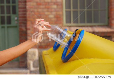 woman throwing plastic bottle Recycling bin stand on european street. Waste separation rubbish before drop to garbage bin to save world, environment care. Pollution trash recycling management concept 107255179