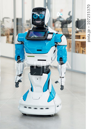 humanoid robot with a friendly face in the interior of a modern office 107255370