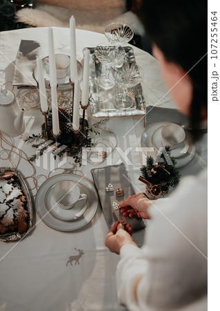 Woman hand setting up table for Christmas dinner Woman hand setting up table for Christmas dinner 107255464