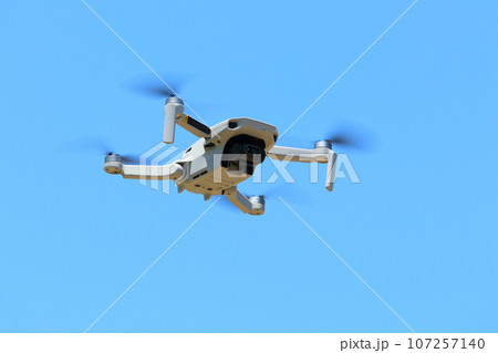 青空にドローンが飛んでいる　空撮撮影現場 107257140