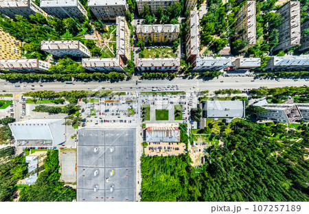 Aerial city view with crossroads and roads, houses, buildings, parks and parking lots. Sunny summer panoramic image Aerial city view with crossroads and roads, houses, buildings, parks and parking lots. Sunny summer panoramic image 107257189