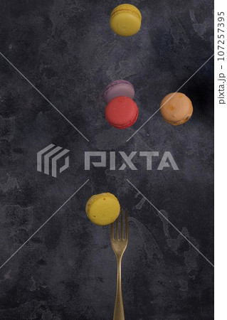 French macarons flying in the air on black background. Levitation French macarons flying in the air on black background. Levitation 107257395