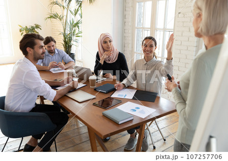 Mixed-race female seminar participant raise hand having question 107257706