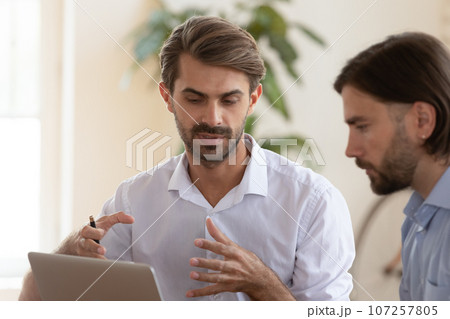 European confident executive manager makes presentation for client using notebook 107257805