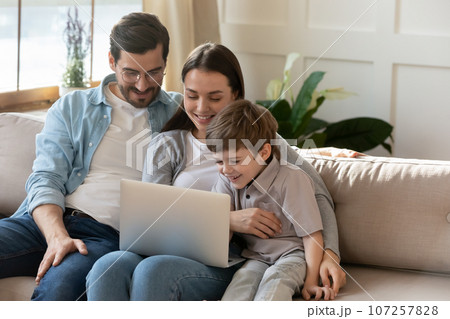 Happy young parents with little son using laptop together 107257828