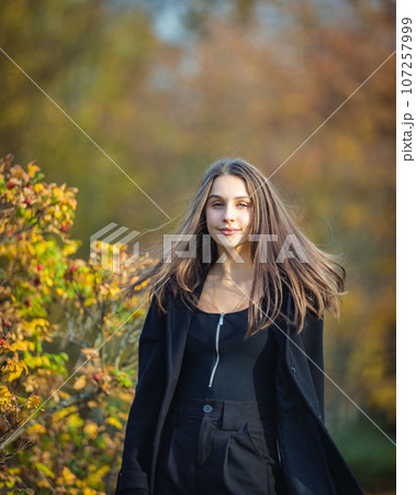 Happy girl spinning in the autumn park. 107257999