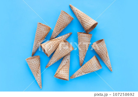 Empty ice cream cone on blue background. 107258692