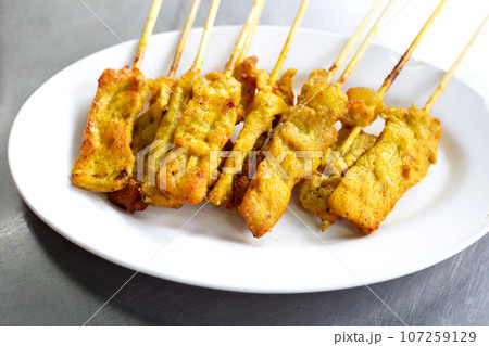 Grilled pork satay on white plate 107259129