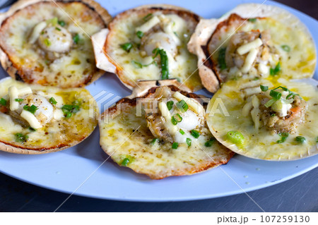 Grilled scallops shell with butter and garlic on white plate Grilled scallops shell with butter and garlic on white plate 107259130