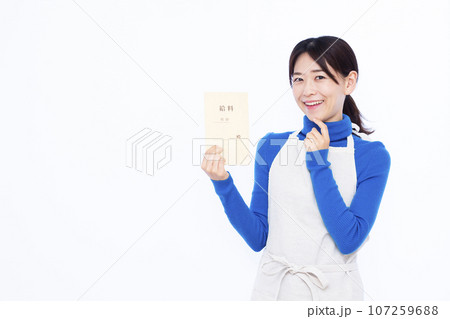 白い背景の前で給料袋を持って考えている笑顔の30代主婦 107259688