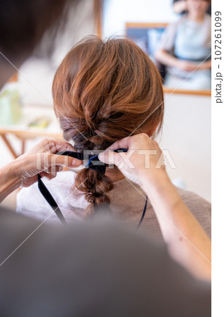 美容院でヘアセットしてもらっている若い女性 107261099