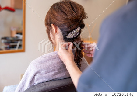 美容院でヘアセットしてもらっている若い女性 107261146