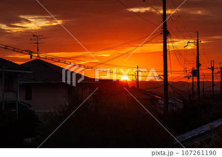 夕焼け色に染まる空と真っ赤な夕日　奈良市の市街地にて 107261190
