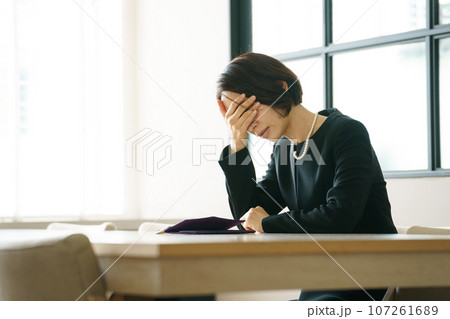 悲しみに暮れる喪服の女性 107261689