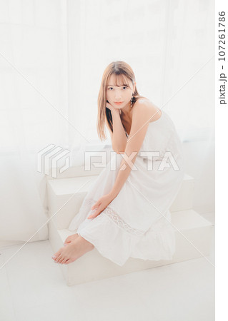 室内に佇む若い女性の写真 107261786