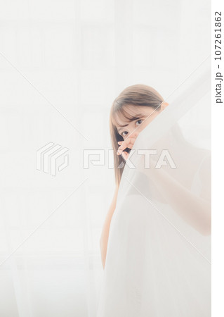 室内に佇む若い女性の写真 107261862