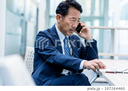 スマホで電話するビジネスパーソン 107264460