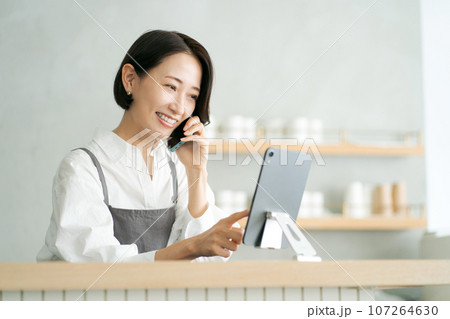 電話をするカフェ店員 107264630