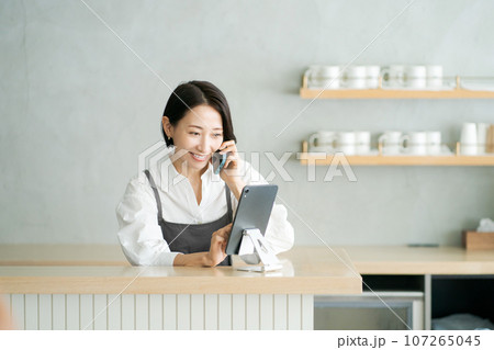 電話をするカフェ店員 電話をするカフェ店員 107265045