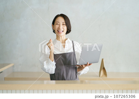 ノートパソコンを持つカフェ店員 107265306