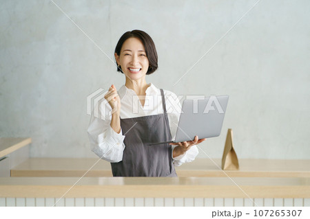 ノートパソコンを持つカフェ店員 107265307
