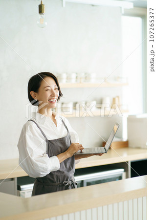 ノートパソコンを持つカフェ店員 107265377