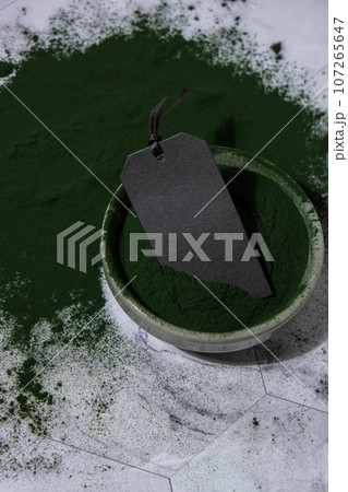 Blue-green algae Chlorella and spirulina powder in bowl with empty paper note mock up copy space. Super powder. Natural supplement of algae. Detox superfood drink cocktail. Food supplement source of Blue-green algae Chlorella and spirulina powder in bowl with empty paper note mock up copy space. Super powder. Natural supplement of algae. Detox superfood drink cocktail. Food supplement source of 107265647