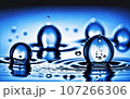 Waves of water drops falling to the surface of the water water droplets spread Blue background and lights 107266306