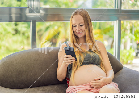 Mobile pregnancy online maternity application. Pregnant mother using phone. Pregnancy, medicine, pharmaceutics, health care and people concept 107266861