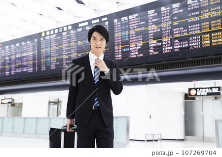 空港から出張をする若いビジネスマン 107269704