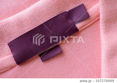 Blank red laundry care clothes label on pink fabric texture background Blank red laundry care clothes label on pink fabric texture background 107270089