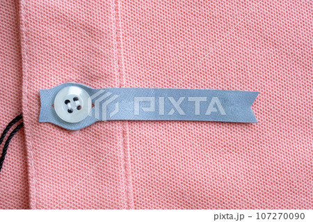 Blank laundry care clothes label on red fabric texture background 107270090