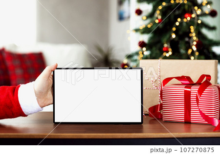 Christmas, New Year background. Santa hand holding blank white tablet screen 107270875